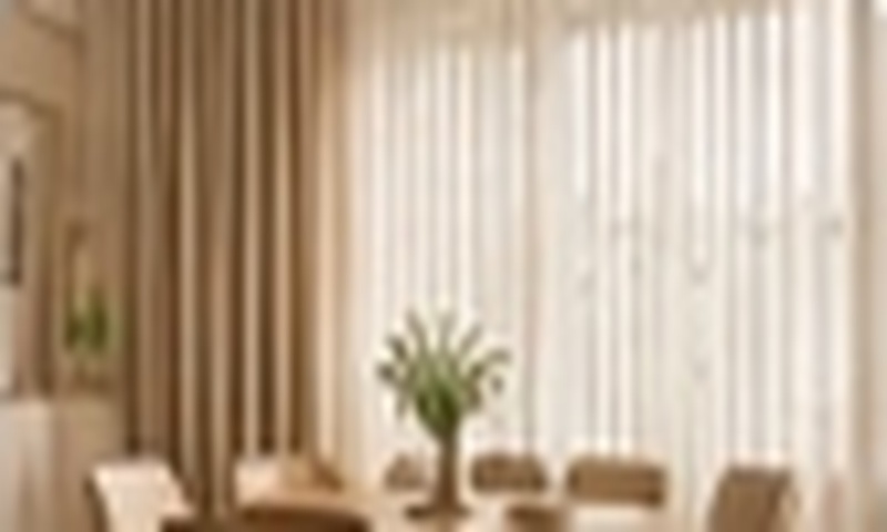 Dining area featuring softly filtered daylight through elegant custom curtains